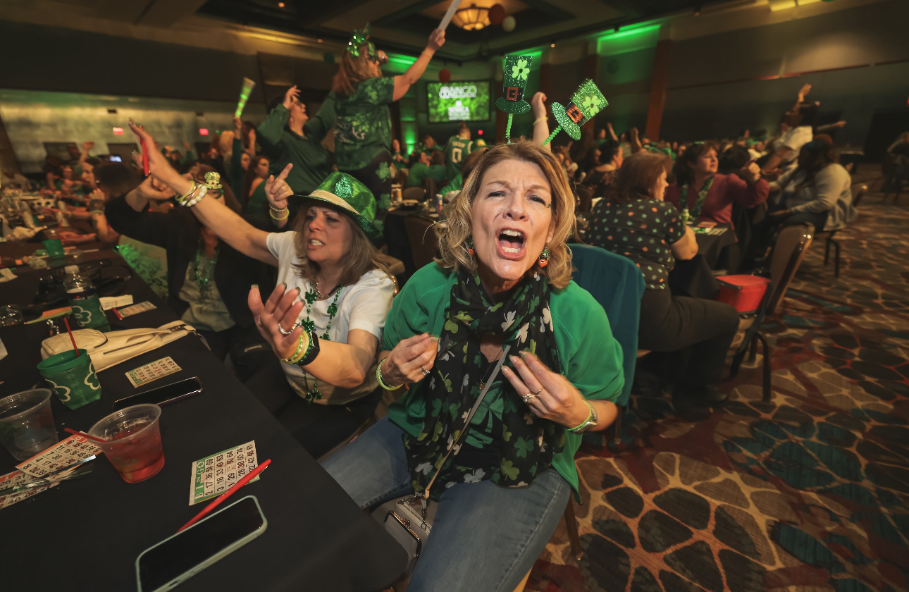 Guests posing with bingo cards at BB’s Bingo